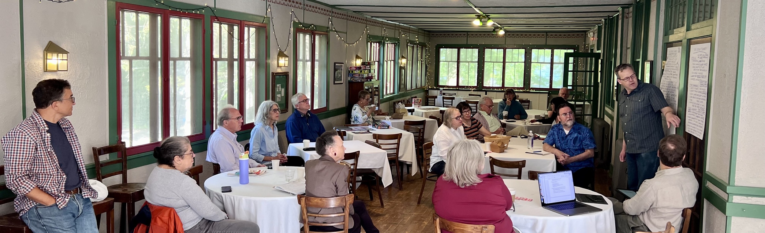 Group of people sitting at tables participating in a discussion